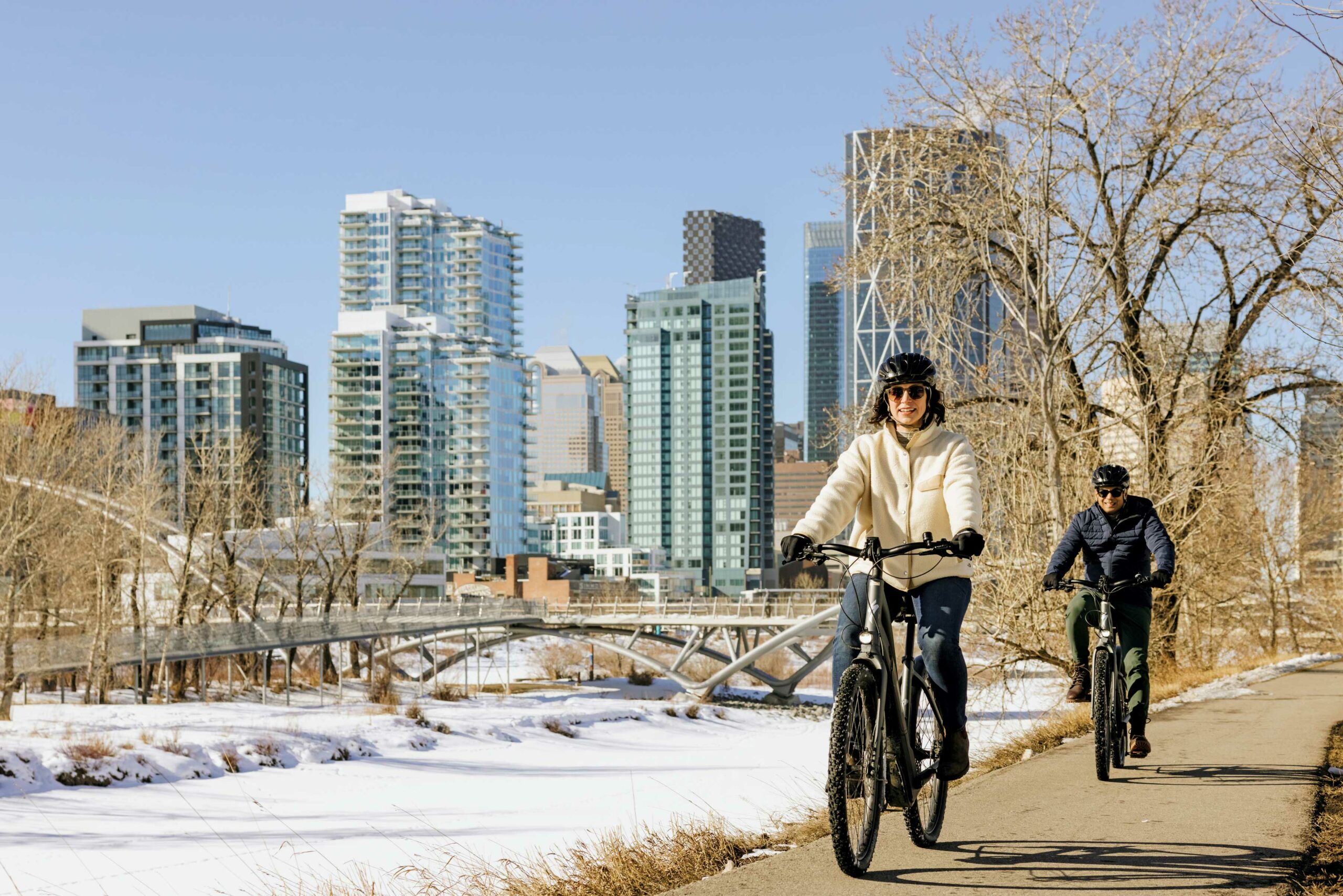 Two people bike in a pathway in Calgary in winter