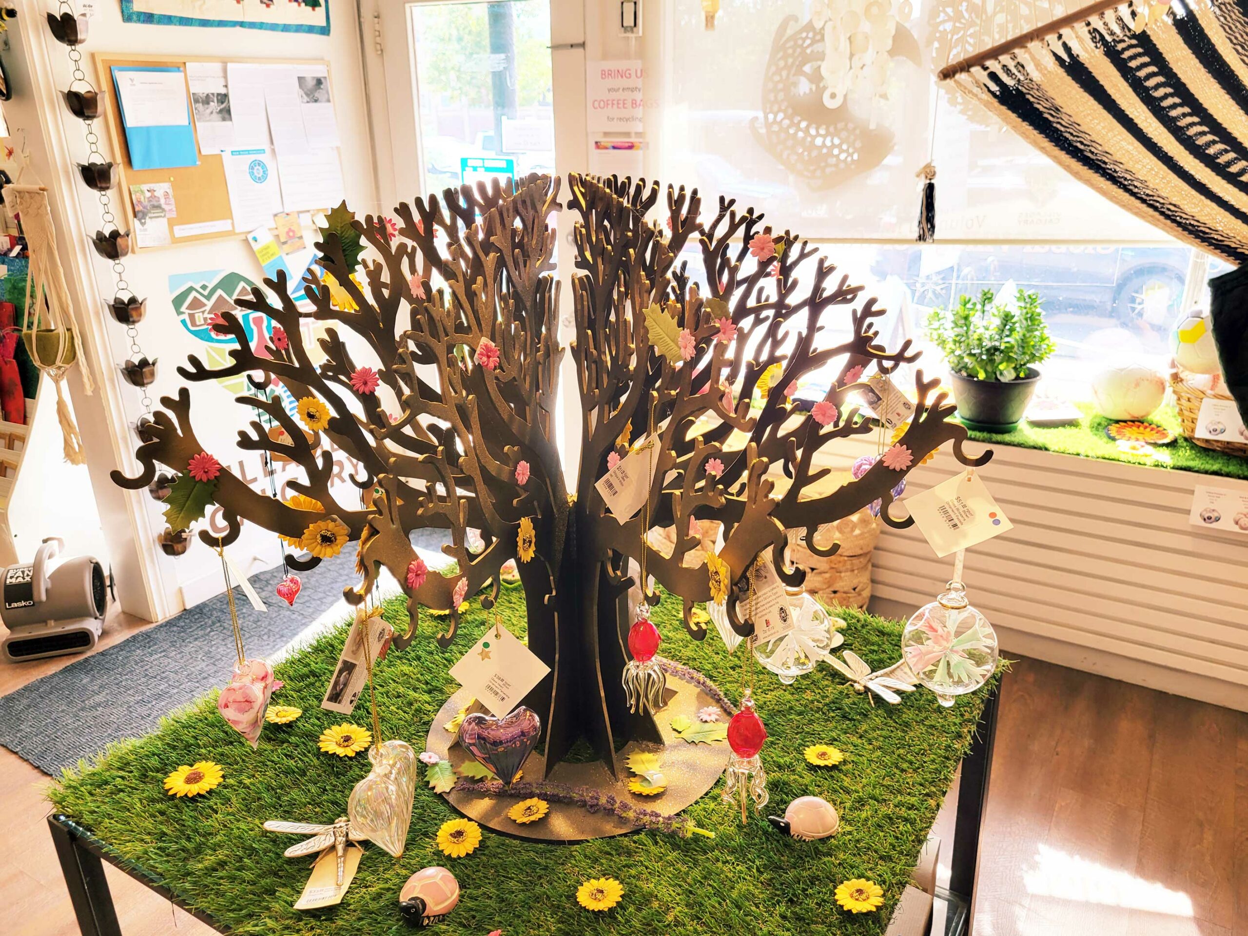 Stylized tree with branches and no leaves decorated with items at Villages Calgary