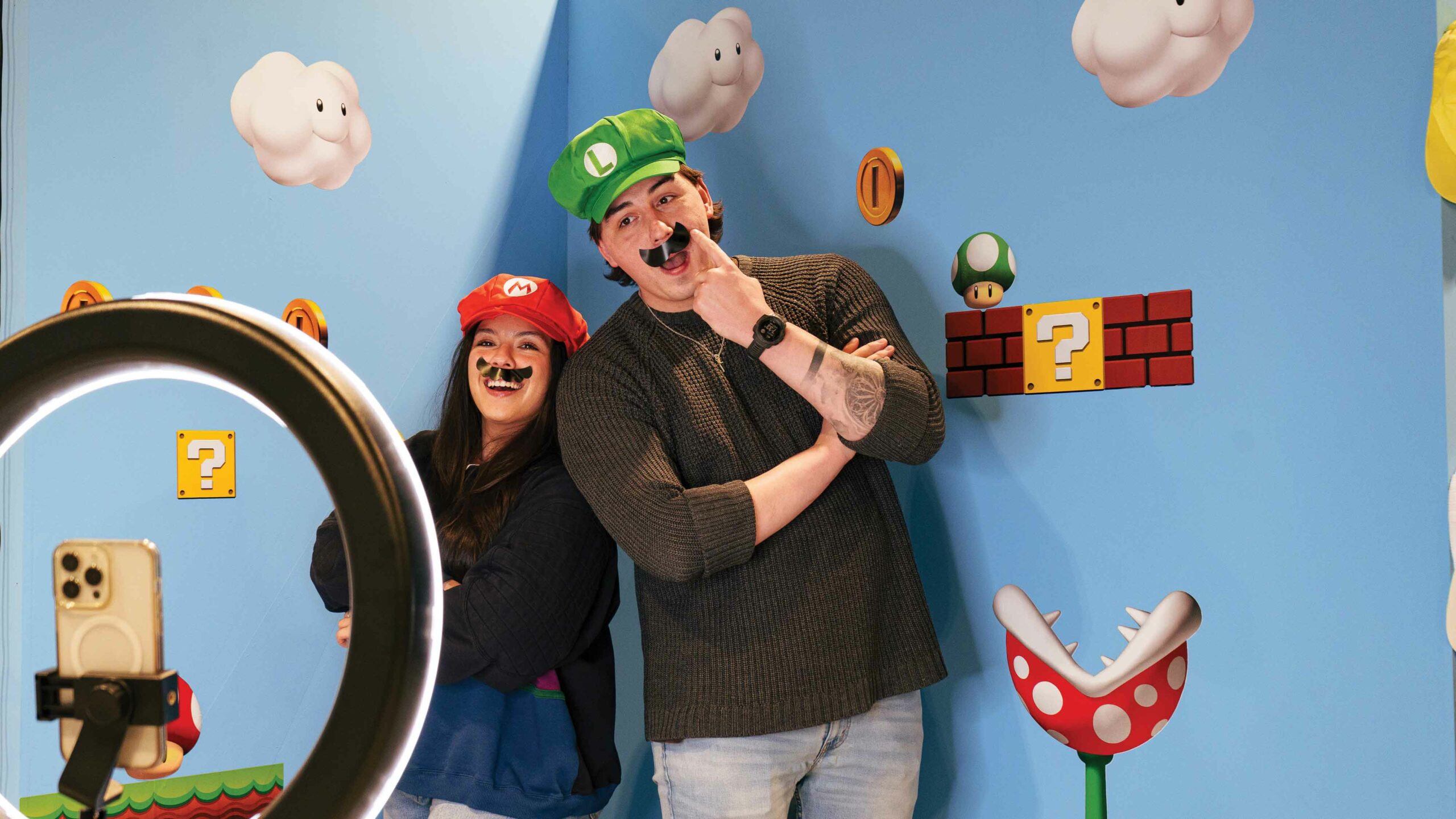 Two people take a photo at The Selfie Museum dressed as the Super Mario Brothers. 