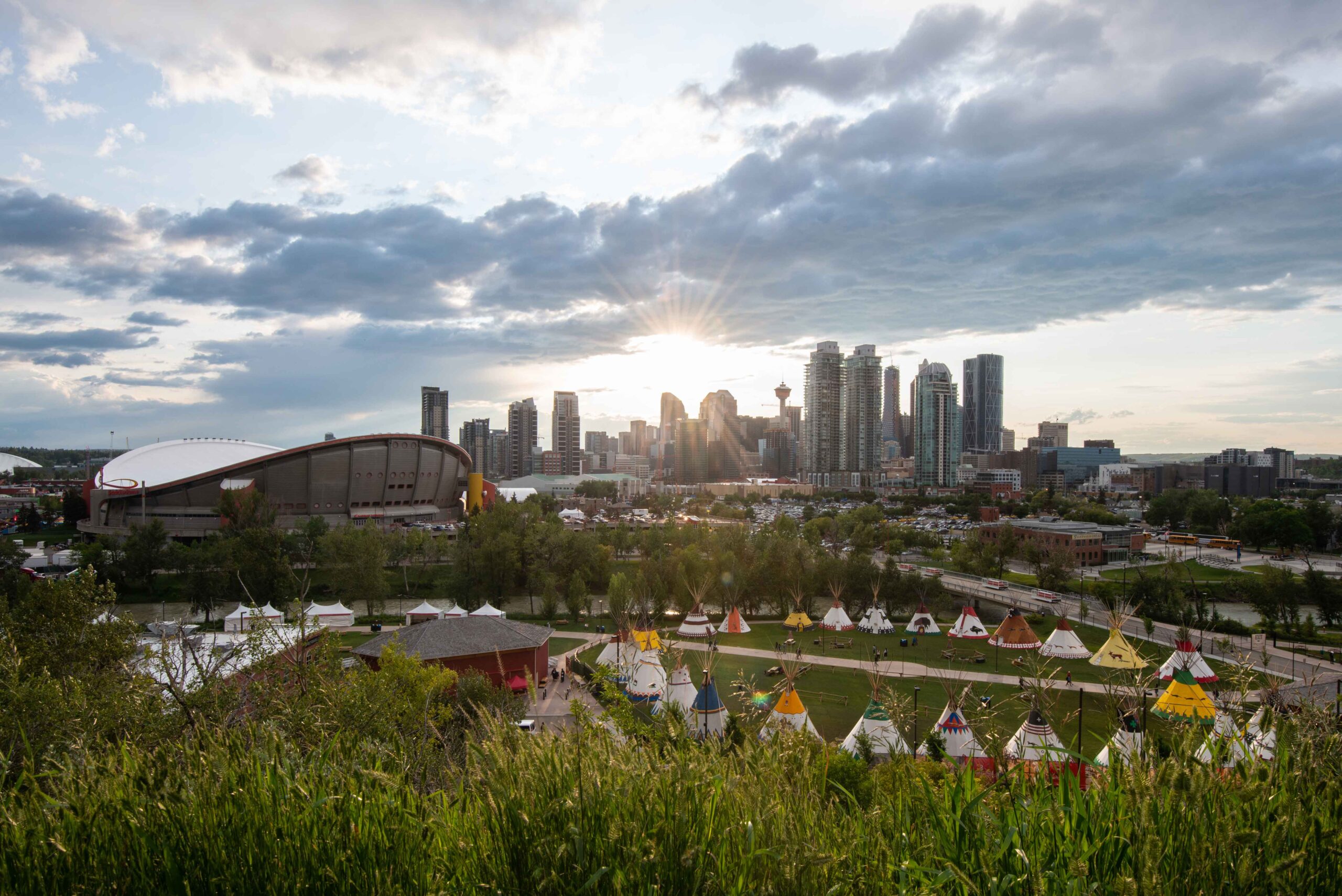 Elbow River Camp at Calgary Stampede against Calgary's downtown skyline backdrop.